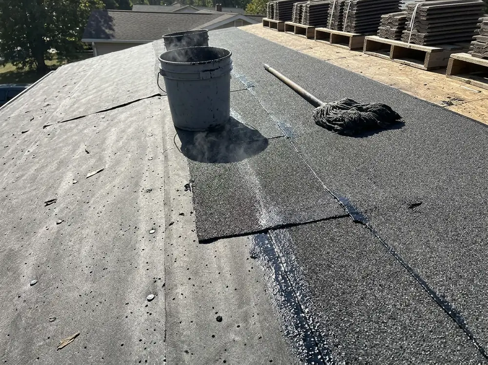 Two-ply roof underlayment with a mineral cap sheet set in hot asphalt over a nailed base sheet, tile not yet loaded